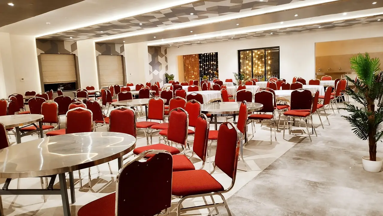 Salón de eventos montado con mesas redondas y sillas para una fiesta